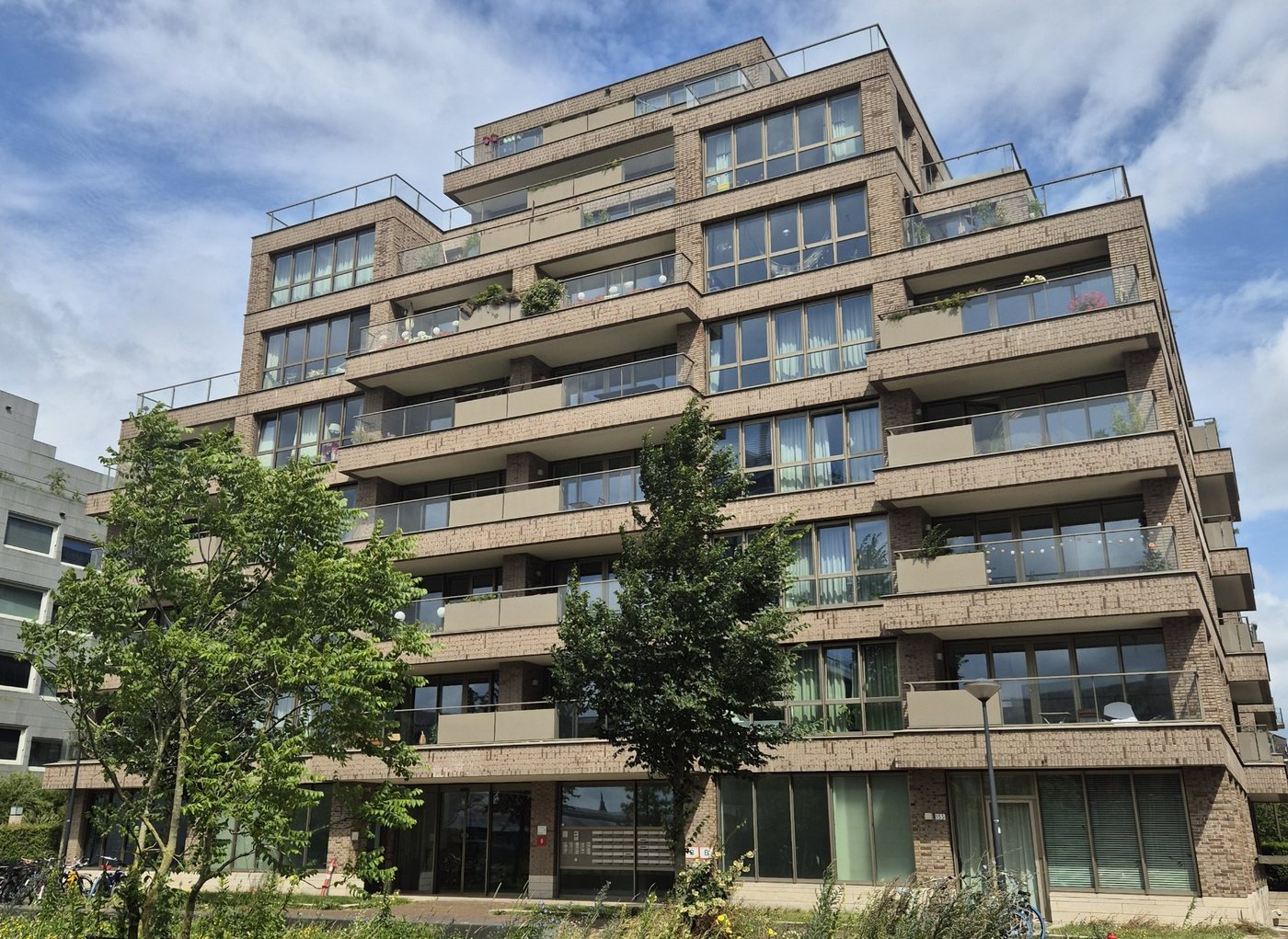 Stepped brick apartment tower with terraces and uPVC window walls