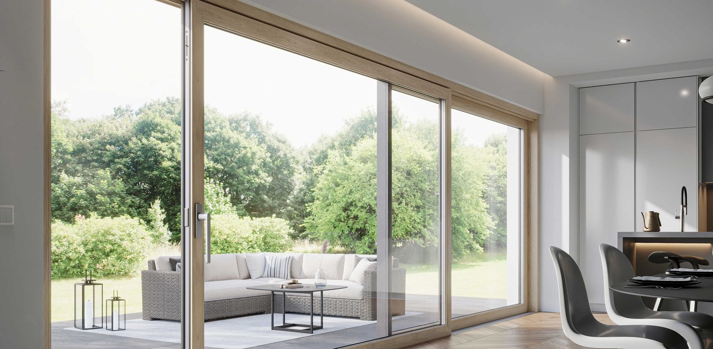Wide oak-look uPVC lift and slide door opened onto a terrace and garden, in a bright living and dining room