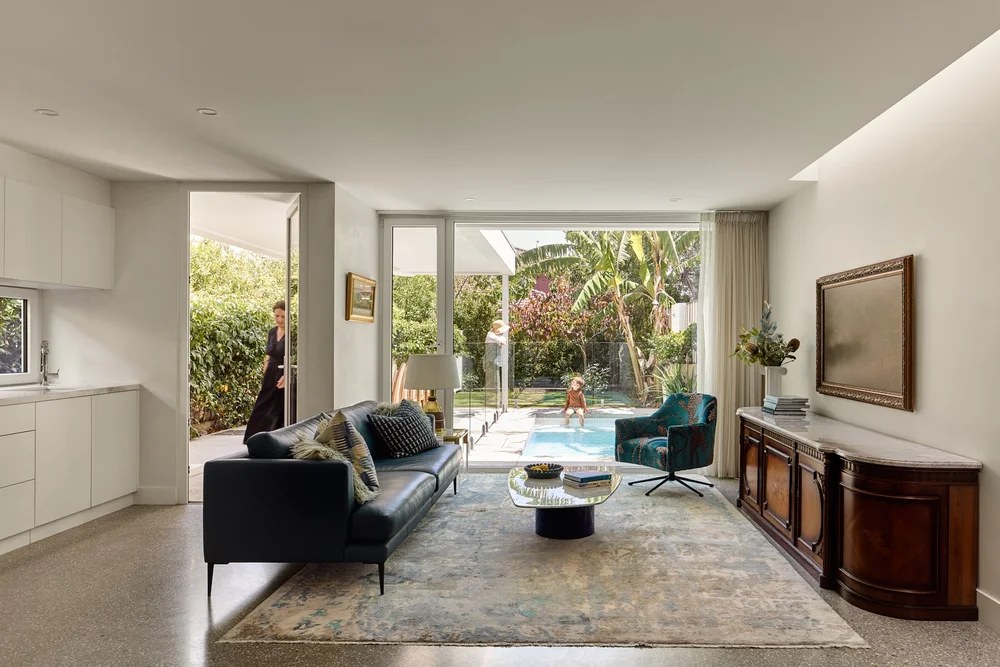 Living room opening through white uPVC doors to a garden and plunge pool