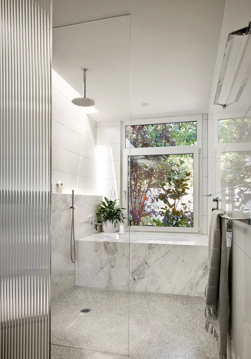 Marble bathroom with a white uPVC window and fixed highlight above the bath