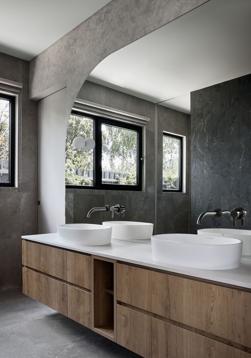 Bathroom vanity with black-framed windows above the basins